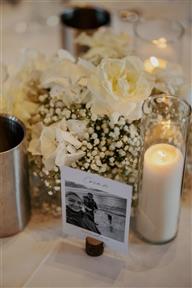 white table posy arrangement with candles in cylinder vases. Repurposed Aisle flowers to tables